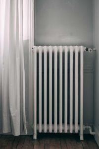 CLassic looking radiator next to a window.