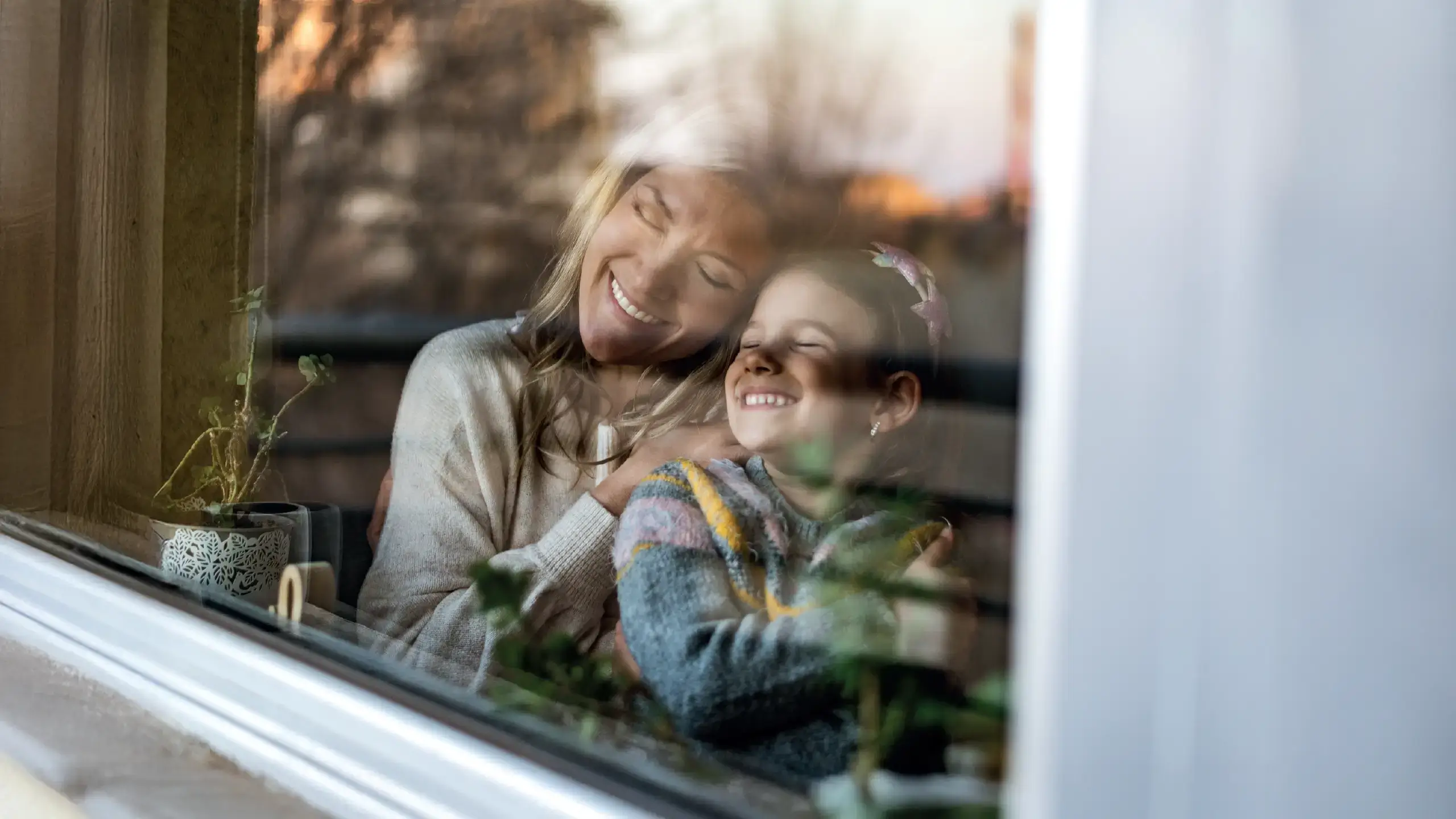 mother and daughter looking out of a window