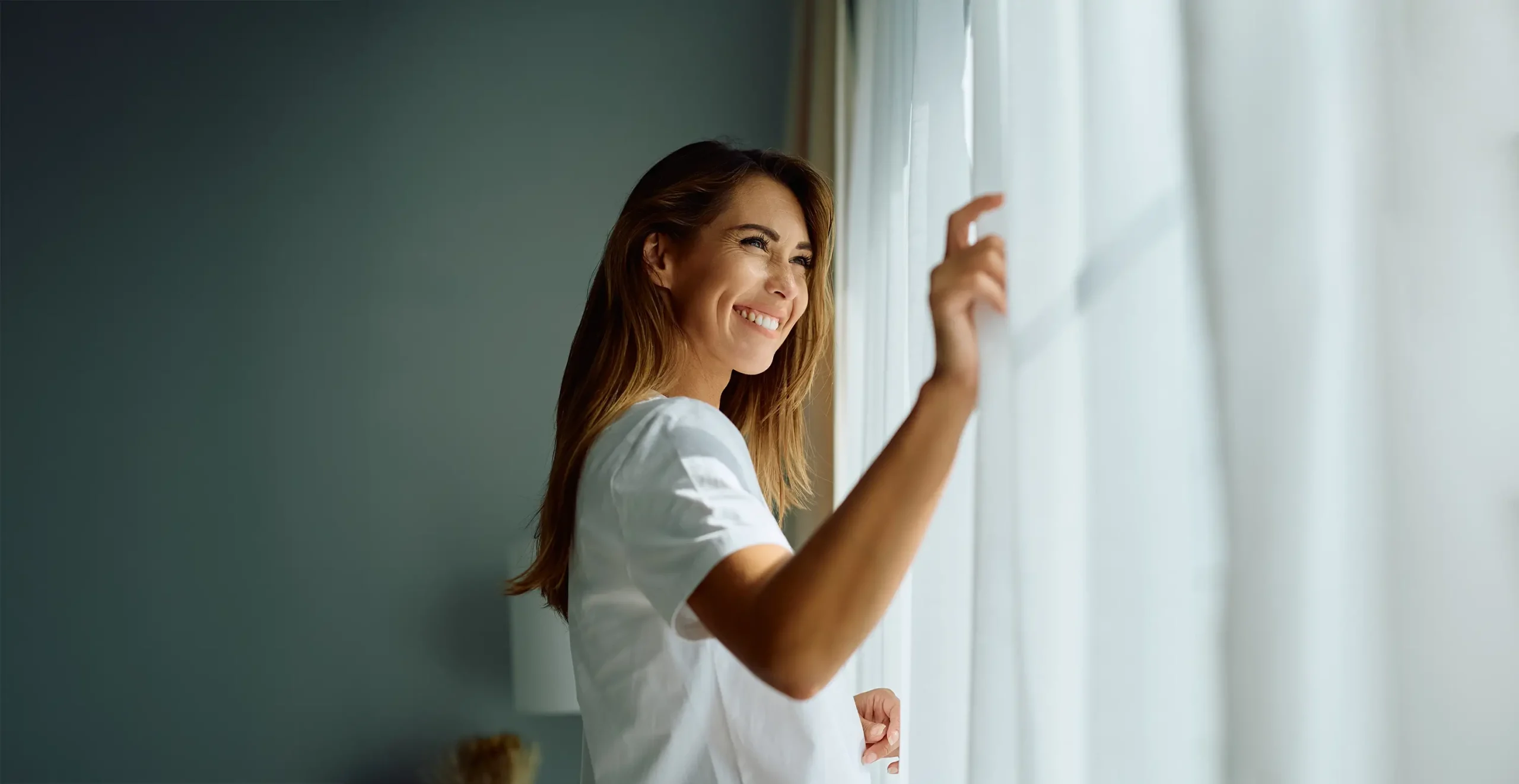 Woman looking through window looking happy